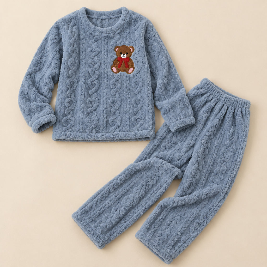 Pyjama hiver fille ourson brodé effet torsadé deux pièces posé à plat sur fond beige, sans personne