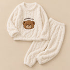Pyjama moumoute femme écru avec ours brun deux pièces posé à plat sur fond beige, sans personne