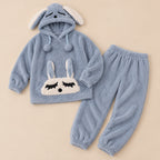 Ensemble pyjama deux pièces Pyjama chaud lapin bleu à capuche adulte posé à plat sur fond beige, sans personne