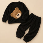 Ensemble pyjama deux pièces Pyjama moumoute femme et ado ours noir doux posé à plat sur fond beige, sans personne