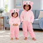 Combinaison pyjama ours rose enfant porté dans un intérieur chaleureux