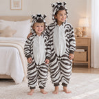 Kigurumi zèbre enfant à motif noir et blanc porté dans un intérieur chaleureux
