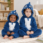Pyjama requin aux grands yeux bébé et enfant porté dans un intérieur chaleureux