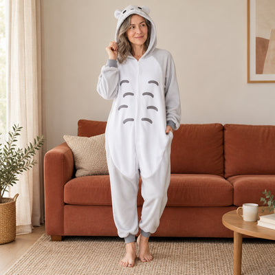 Pyjama costume animal gris à ventre blanc adulte porté de face dans un intérieur chaleureux