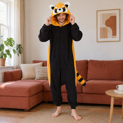 Pyjama costume panda roux adulte noir et orange porté de face dans un intérieur chaleureux